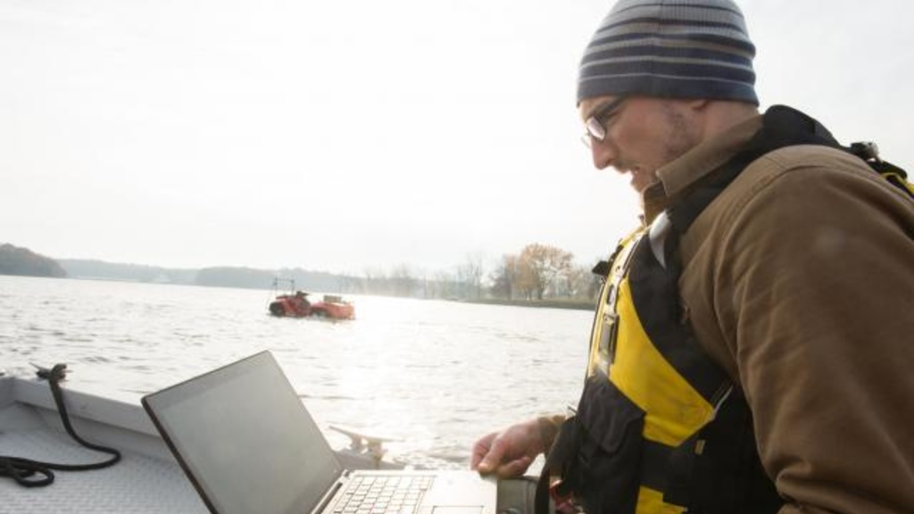 Casey Harwood looks at data on a laptop at the Coralville Reservoir